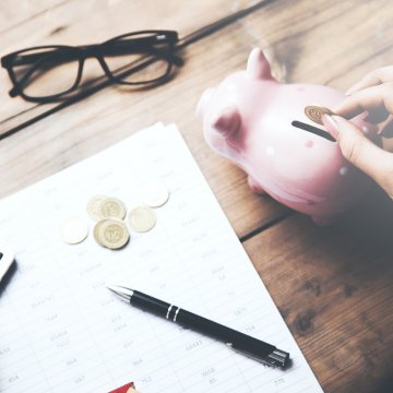 savings root car insurance car insurance hand putting money in piggy bank glasses calculator change pen contract on wooden table